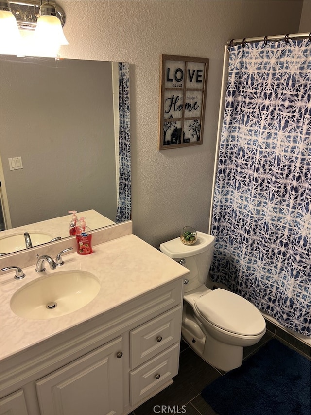 bathroom featuring vanity, toilet, and walk in shower