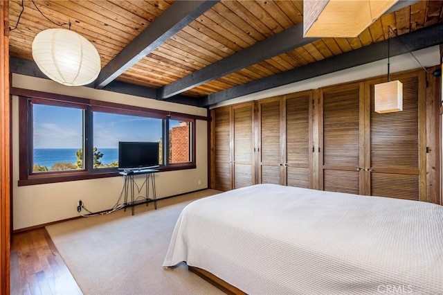 bedroom featuring beamed ceiling, light hardwood / wood-style floors, and wooden ceiling