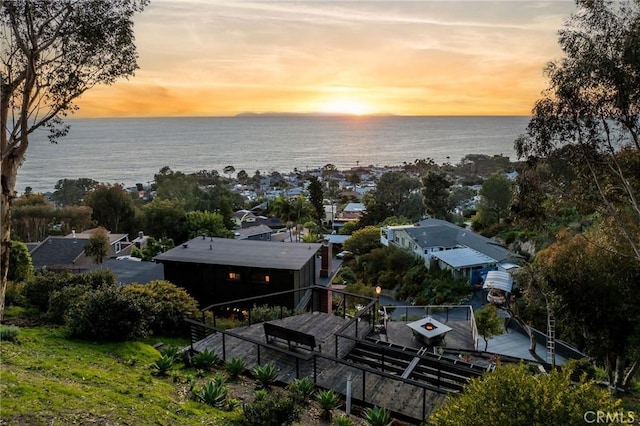 aerial view at dusk featuring a water view