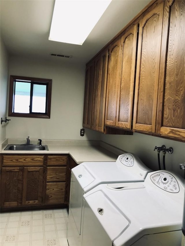 laundry room with cabinets, independent washer and dryer, and sink