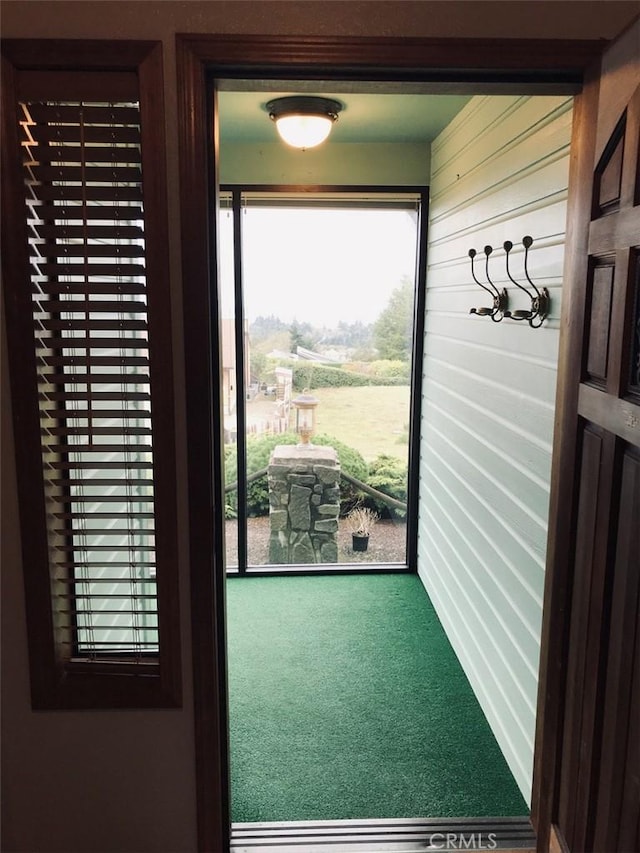 doorway to outside with carpet flooring