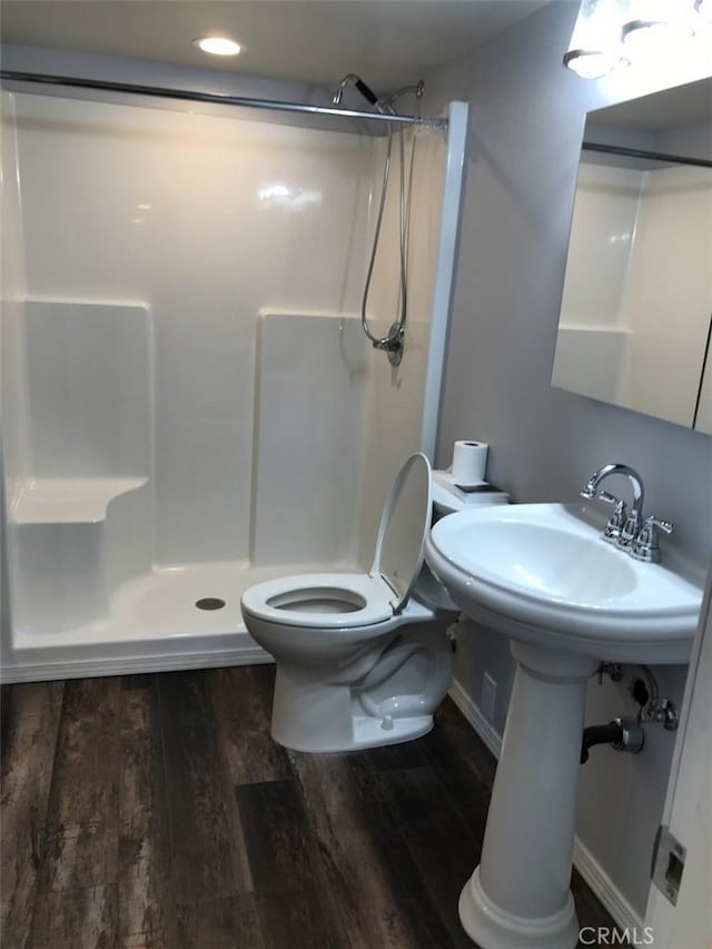 bathroom with wood-type flooring, toilet, and walk in shower