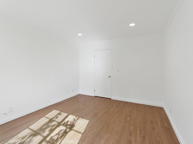 spare room featuring hardwood / wood-style floors and crown molding