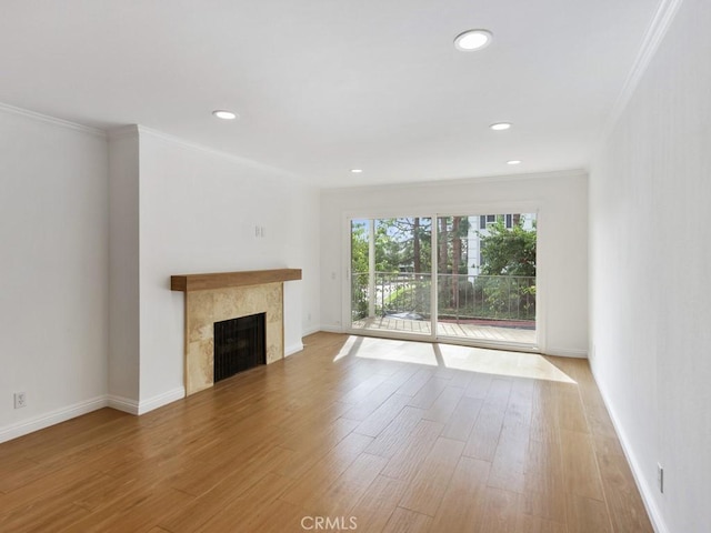 unfurnished living room with a high end fireplace, crown molding, and wood-type flooring