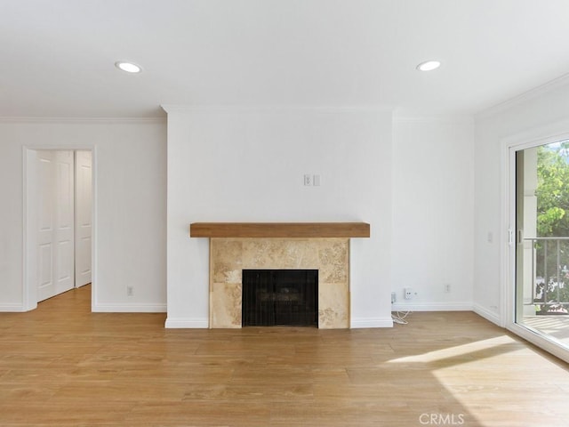 unfurnished living room featuring a fireplace, ornamental molding, and wood-type flooring