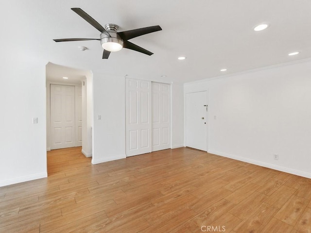 empty room with ornamental molding, light wood-type flooring, and ceiling fan