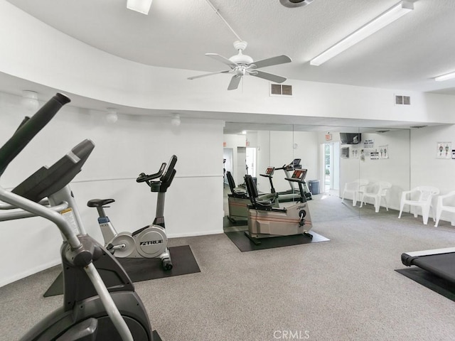 workout room featuring a textured ceiling, ceiling fan, and carpet flooring