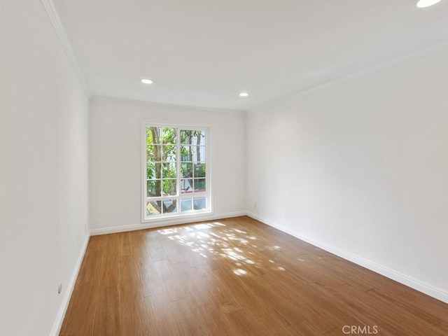 unfurnished room with hardwood / wood-style flooring and ornamental molding