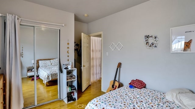 bedroom with light hardwood / wood-style floors and a closet