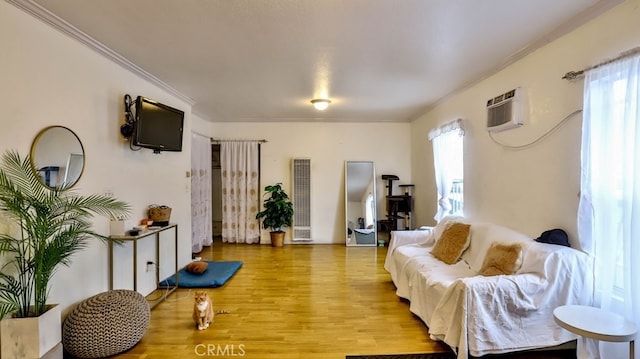 living room with ornamental molding, a wall mounted AC, and light hardwood / wood-style flooring