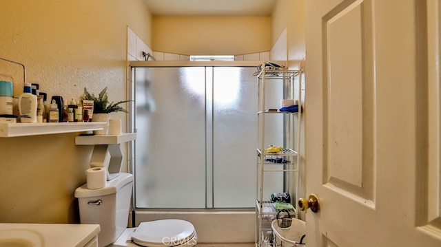 full bathroom with combined bath / shower with glass door, vanity, and toilet