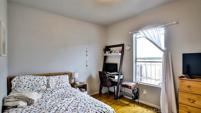 bedroom with multiple windows and wood-type flooring