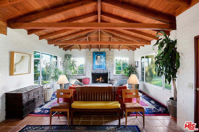 sunroom featuring wooden ceiling, vaulted ceiling with beams, and a large fireplace