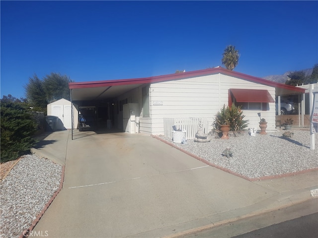 view of side of home with a carport and a shed