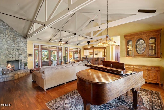 misc room with ceiling fan with notable chandelier, french doors, a fireplace, dark hardwood / wood-style floors, and high vaulted ceiling