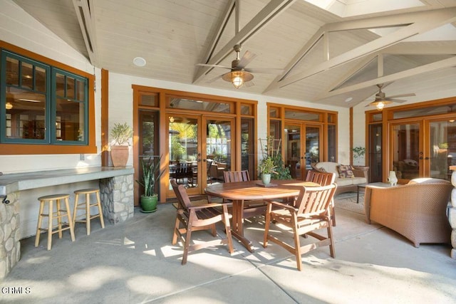 sunroom / solarium with ceiling fan, french doors, and vaulted ceiling with skylight