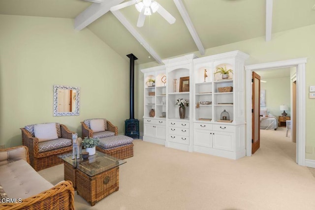 sitting room featuring ceiling fan, light colored carpet, lofted ceiling with beams, and a wood stove