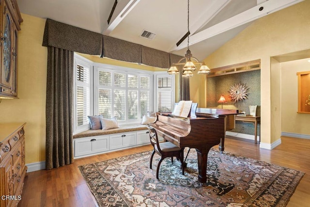 miscellaneous room featuring wood-type flooring, a chandelier, and vaulted ceiling with beams