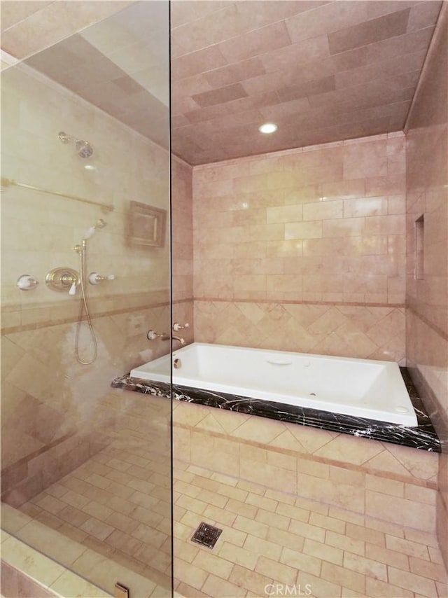 bathroom featuring tiled shower, tile walls, and a bath