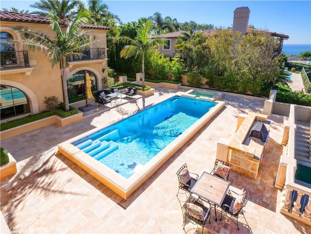 view of swimming pool featuring outdoor dining area, a patio area, and a pool with connected hot tub