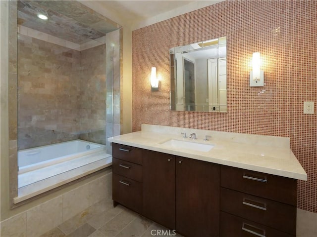 full bath with vanity, walk in shower, a bathing tub, and tile walls