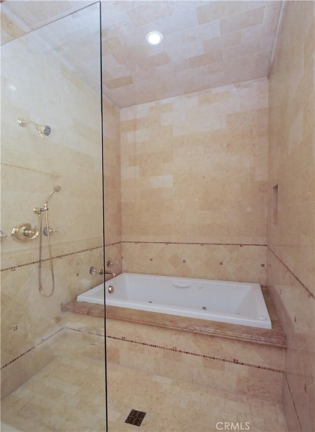 full bath featuring a washtub, tiled shower, and tile walls