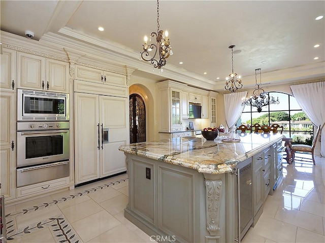 kitchen featuring built in appliances, arched walkways, light tile patterned flooring, cream cabinetry, and a warming drawer