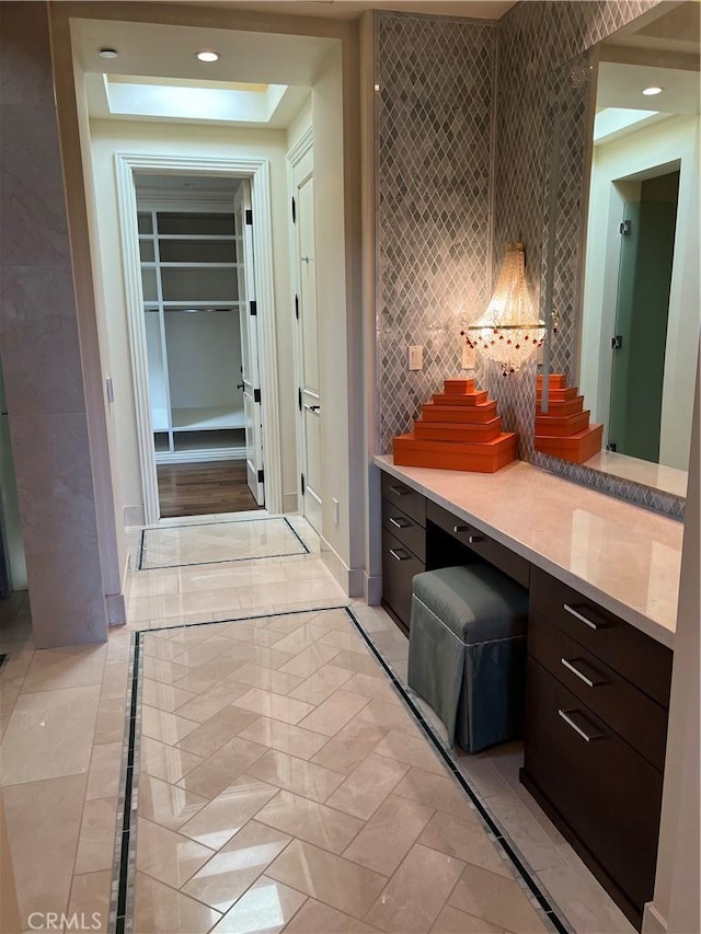 bathroom with decorative backsplash, recessed lighting, vanity, and baseboards