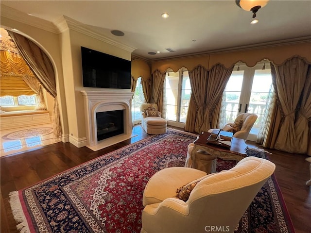 living area featuring recessed lighting, a fireplace, wood finished floors, and crown molding