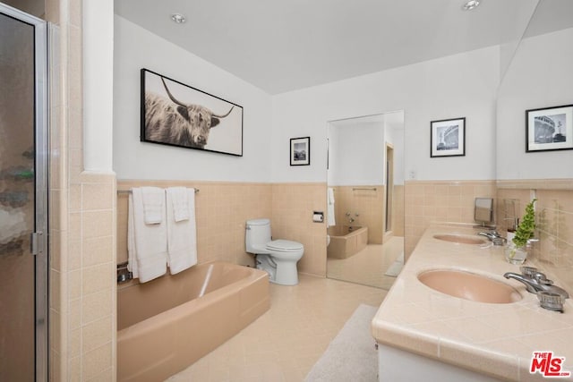 full bathroom featuring tile walls, a bidet, double vanity, toilet, and shower with separate bathtub