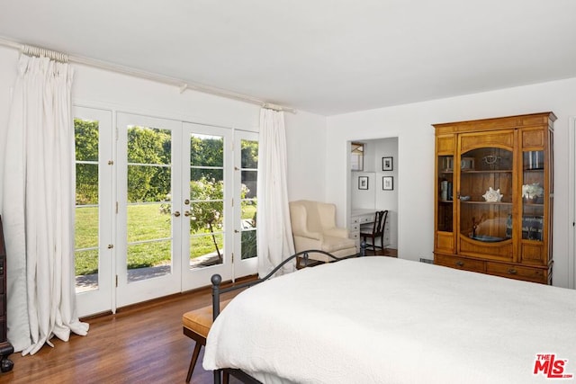 bedroom with multiple windows, dark wood-type flooring, access to exterior, and french doors