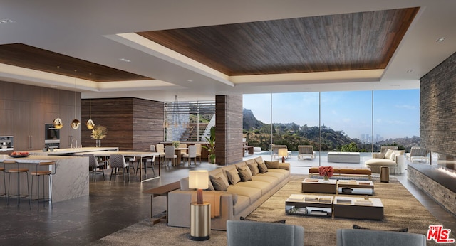 tiled living room featuring a raised ceiling, wood ceiling, and expansive windows