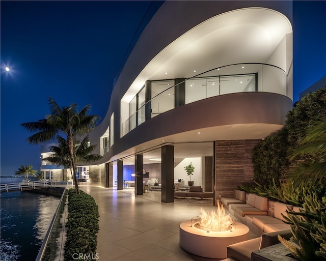 exterior space with an outdoor living space with a fire pit and a patio