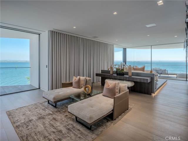 living room with a water view and light hardwood / wood-style floors