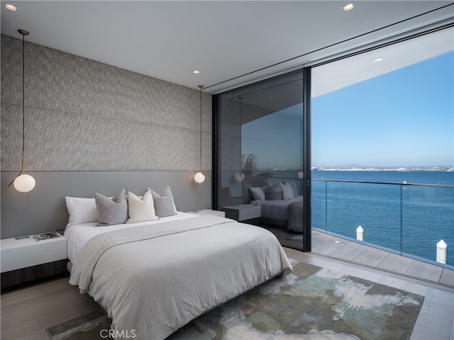 bedroom with a water view and wood-type flooring