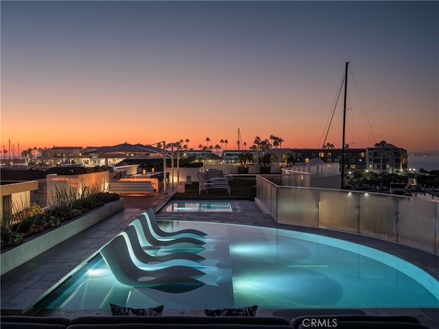 pool at dusk with a patio