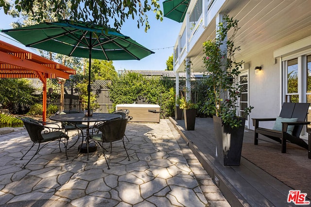 view of patio / terrace with a jacuzzi and a pergola