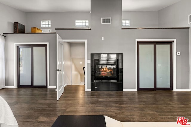 living room featuring plenty of natural light, dark hardwood / wood-style floors, and a tile fireplace