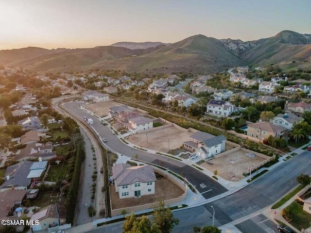 aerial view at dusk featuring a mountain view