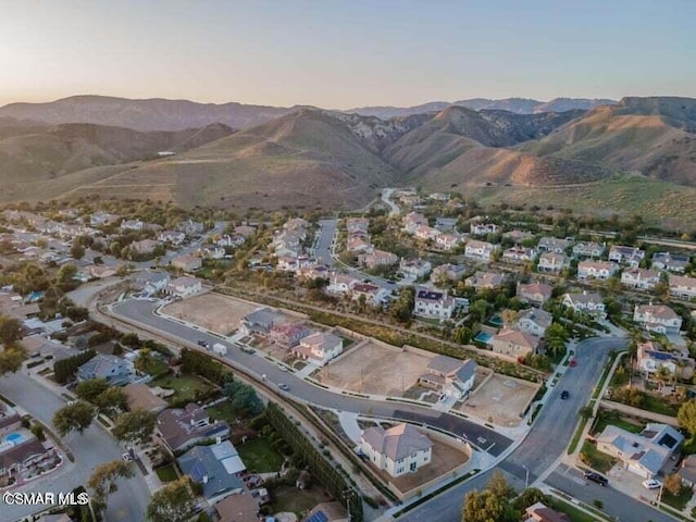 aerial view at dusk featuring a mountain view