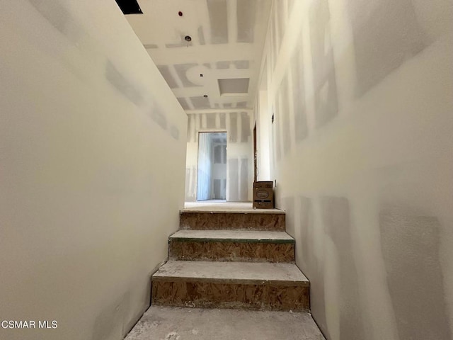 staircase featuring concrete flooring