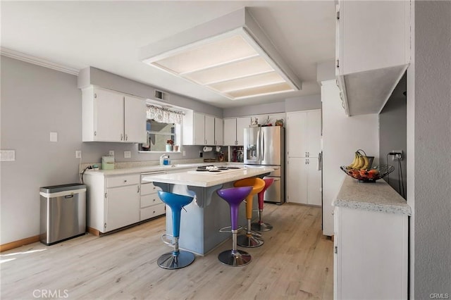 kitchen with white gas cooktop, white cabinetry, stainless steel fridge with ice dispenser, and light hardwood / wood-style flooring