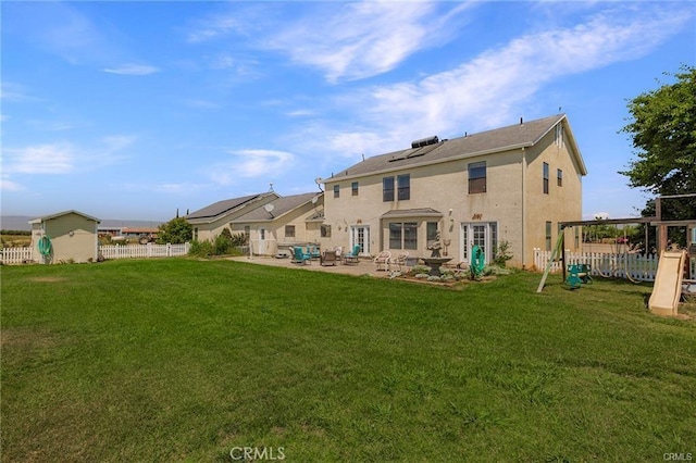 rear view of house featuring a patio area, a playground, and a yard