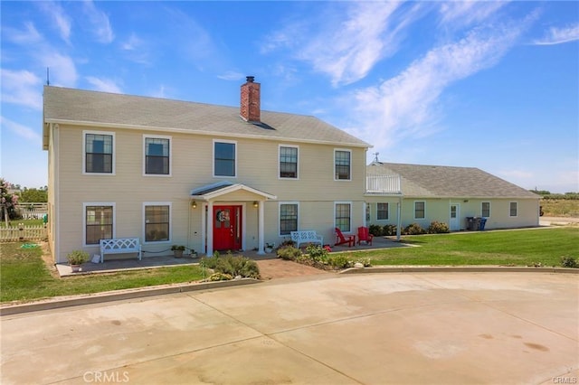 colonial home with a front yard and a patio