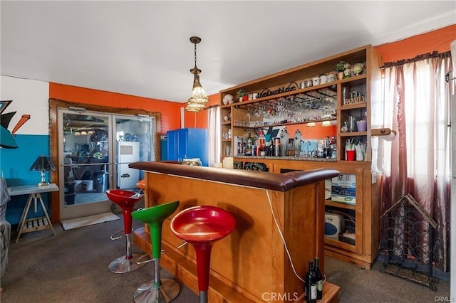 bar with dark carpet and hanging light fixtures