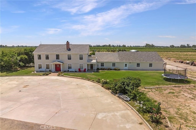 view of front of property featuring a trampoline and a front lawn