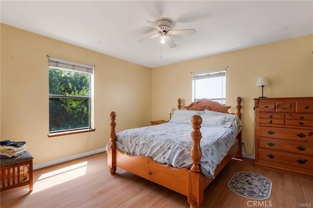 bedroom with light hardwood / wood-style flooring, multiple windows, and ceiling fan