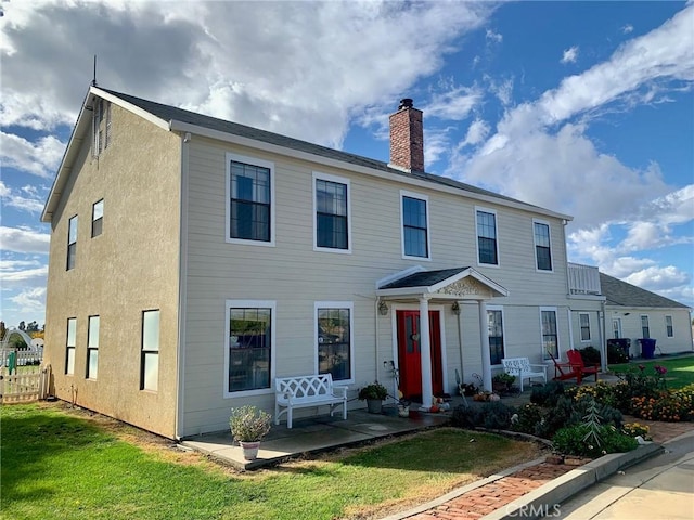 view of front of home with a patio area and a front yard