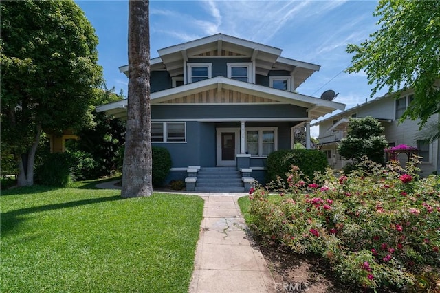 view of front facade featuring covered porch and a front yard