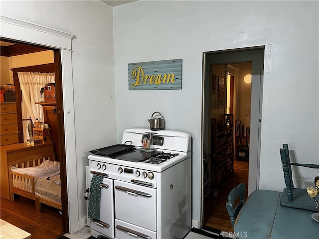 kitchen with white gas range and hardwood / wood-style flooring